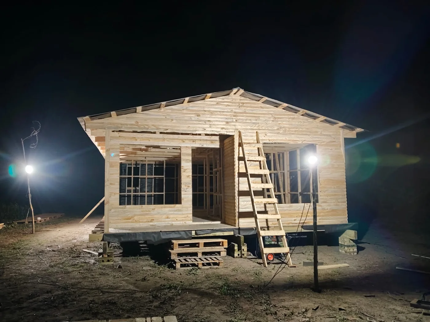 Armado de casa de madera trabajando de noche con iluminación de faena